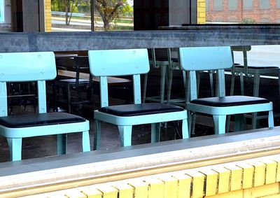 Empty chairs and tables in row