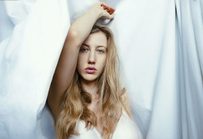 Portrait of young woman lying on bed