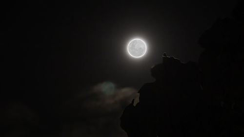 Low angle view of silhouette moon against sky at night