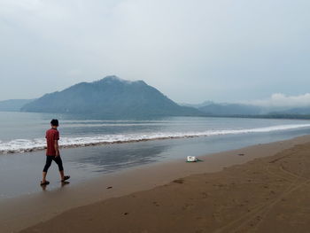 Full length of man on beach against sky