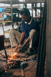 Workshop worker cutting iron plate with cutting machine tool