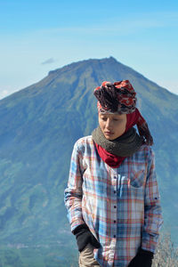 Woman standing on mountain against sky