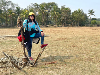 Woman standing with anchor near riverside