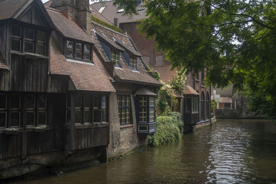 Houses by river and buildings in city