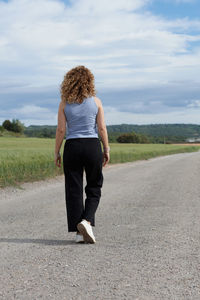 Rear view of woman walking on road