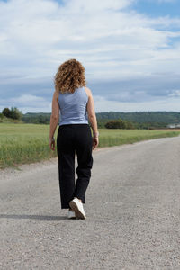 Woman walking on the road to the horizon