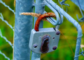 Close-up of rusty padlock on fence