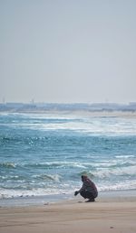 Man on horse at beach against clear sky