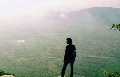 Rear view of man standing on mountain