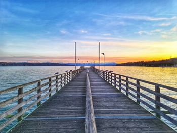 Pier over sea against sky during sunset