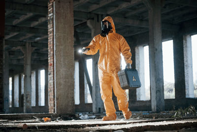 Rear view of woman standing against wall