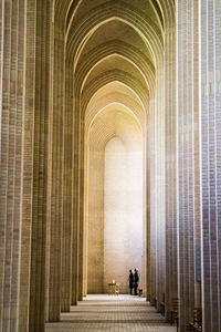 Rear view of people walking in corridor of building