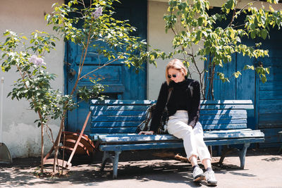Portrait of woman sitting on chair against plants