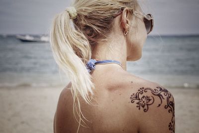 Rear view of woman standing at beach