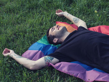 Midsection of man relaxing on field