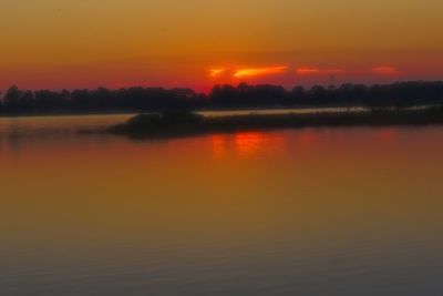 Scenic view of silhouette trees against orange sky