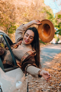 Portrait of a smiling young woman holding camera