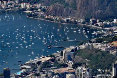 Aerial view of buildings by boats in sea