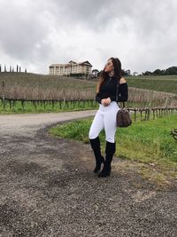 Full length of woman standing in farm against sky