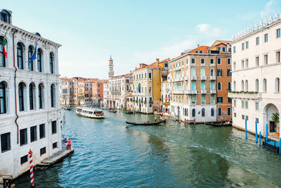 Boats in canal amidst buildings in city