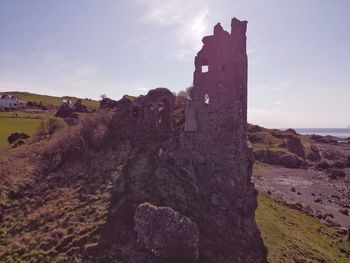 Old ruin building by sea against sky