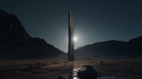 Rear view of woman standing on mountain against sky at night