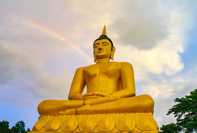 Low angle view of statue against temple against sky