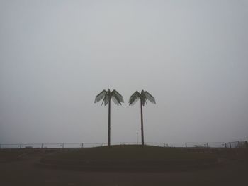 Palm trees on field against clear sky