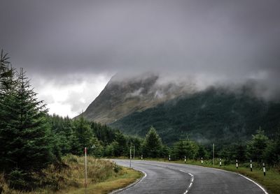 Road by mountains against sky