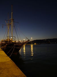 Sailboats moored in sea against clear sky