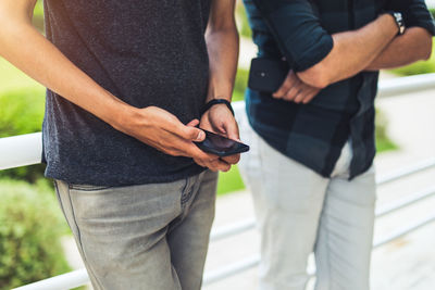 Midsection of man using mobile phone