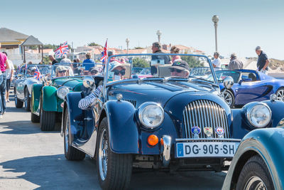 People on street in city against blue sky