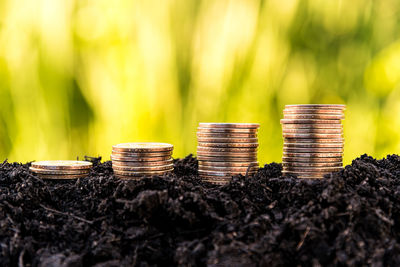 Close-up of stacked coins on soil