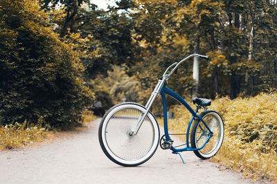 Bicycle on road against trees