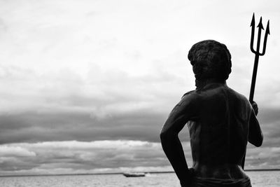 Silhouette of woman against cloudy sky