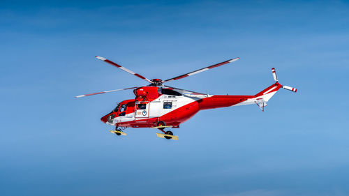 Low angle view of helicopter flying against sky