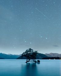 Scenic view of lake against sky at night