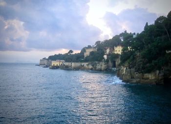 Scenic view of sea by buildings against sky