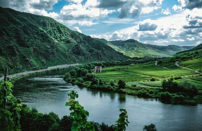 Scenic view of river amidst mountains against cloudy sky