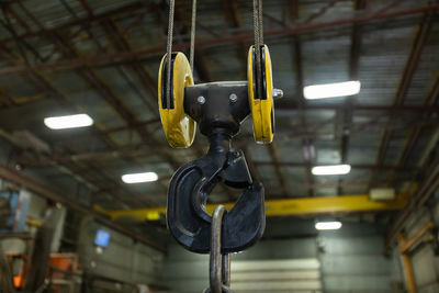 Low angle view of crane hook in factory