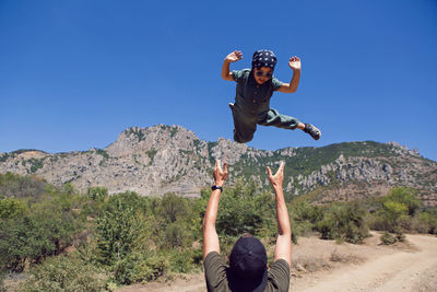 Father throws son up in the mountains in the summer in the crimea