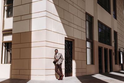 Full length of businessman standing outside building in city