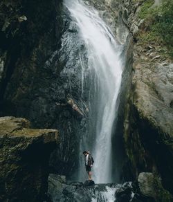 Full length of man standing by waterfall