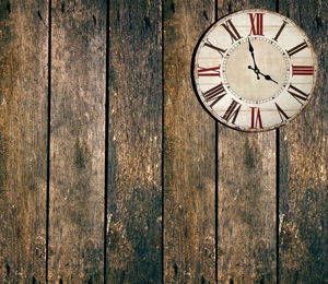 Close-up of wall clock on wooden planks