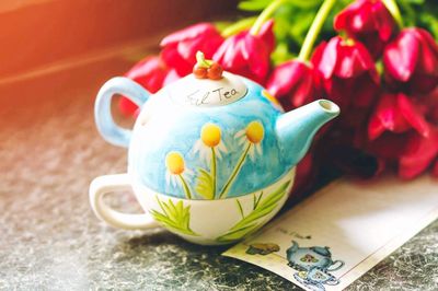 Close-up of teapot with flowers on table