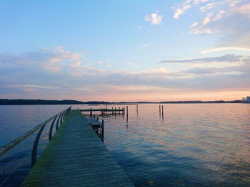 Pier over sea against sky during sunset