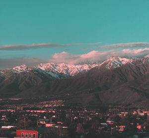 Aerial view of townscape and mountains against sky