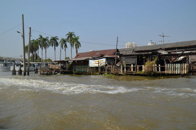 Houses by sea against clear sky