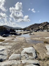 Surface level of rocks on shore against sky