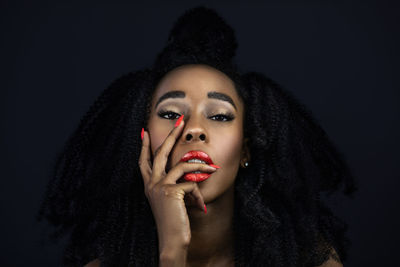 Portrait of a beautiful young woman over black background